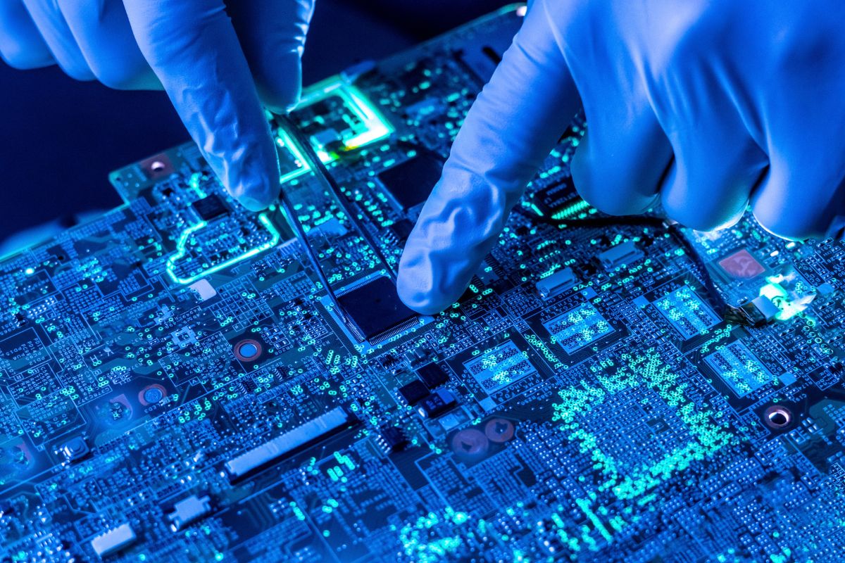 Gloved Hands Carefully Examining a PCB circuit board